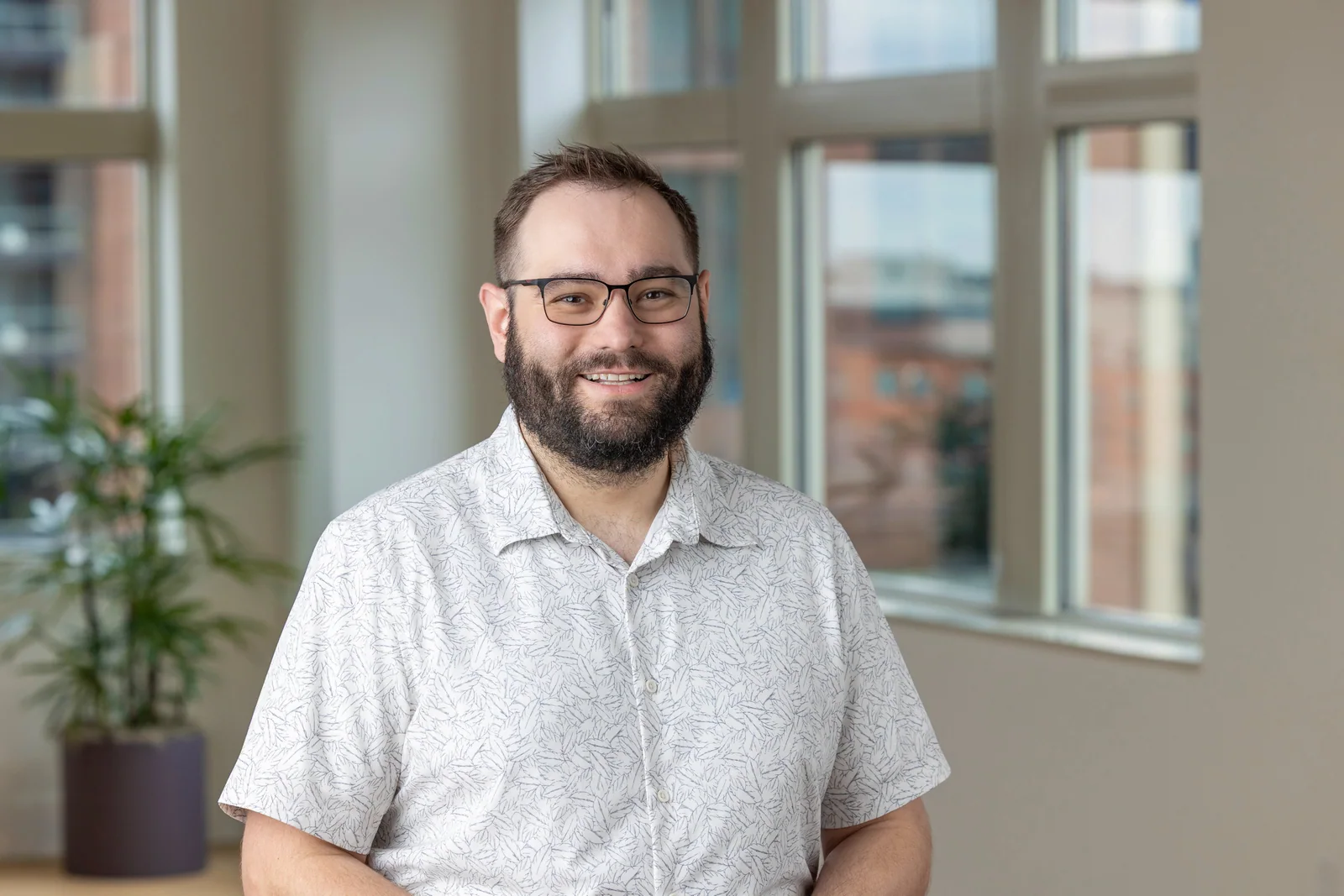 Grant Wasil smiling in a sunlit office